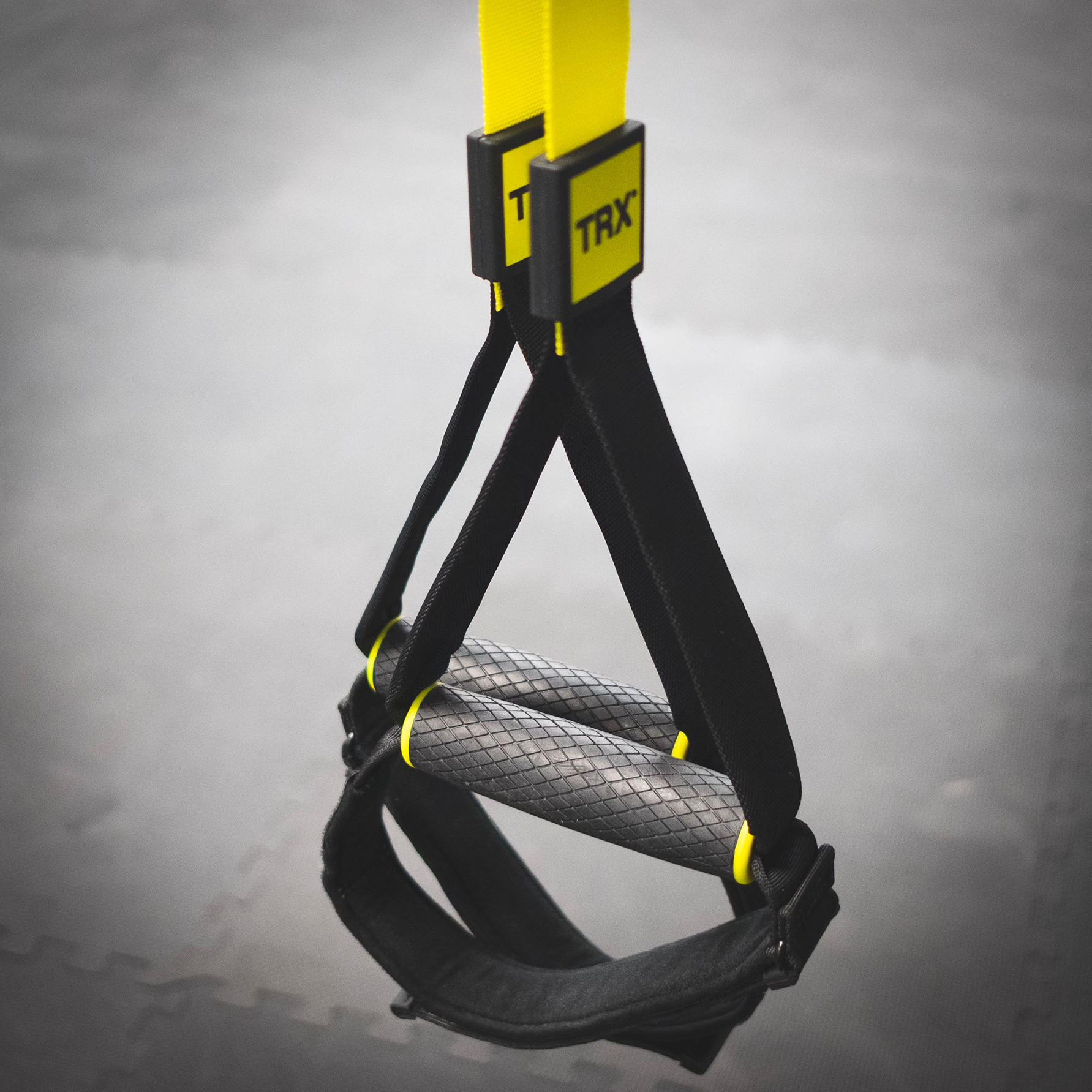 A black and yellow squat bar with yellow handles perfect for women's fitness training.