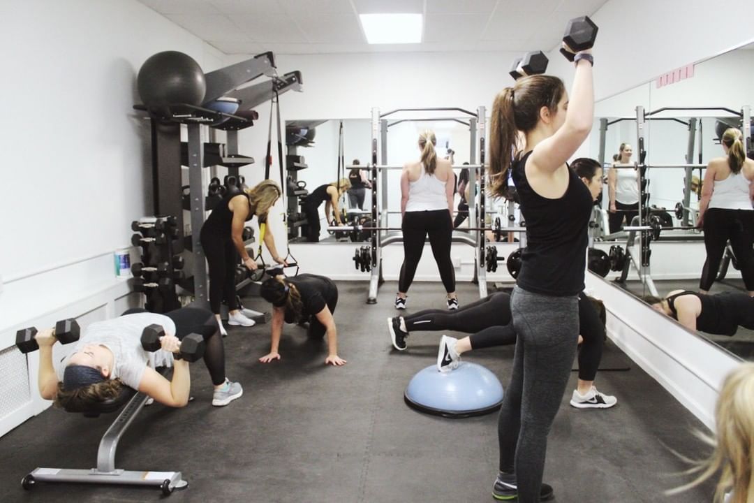 A group of people working out together in a gym while considering the pricing options.