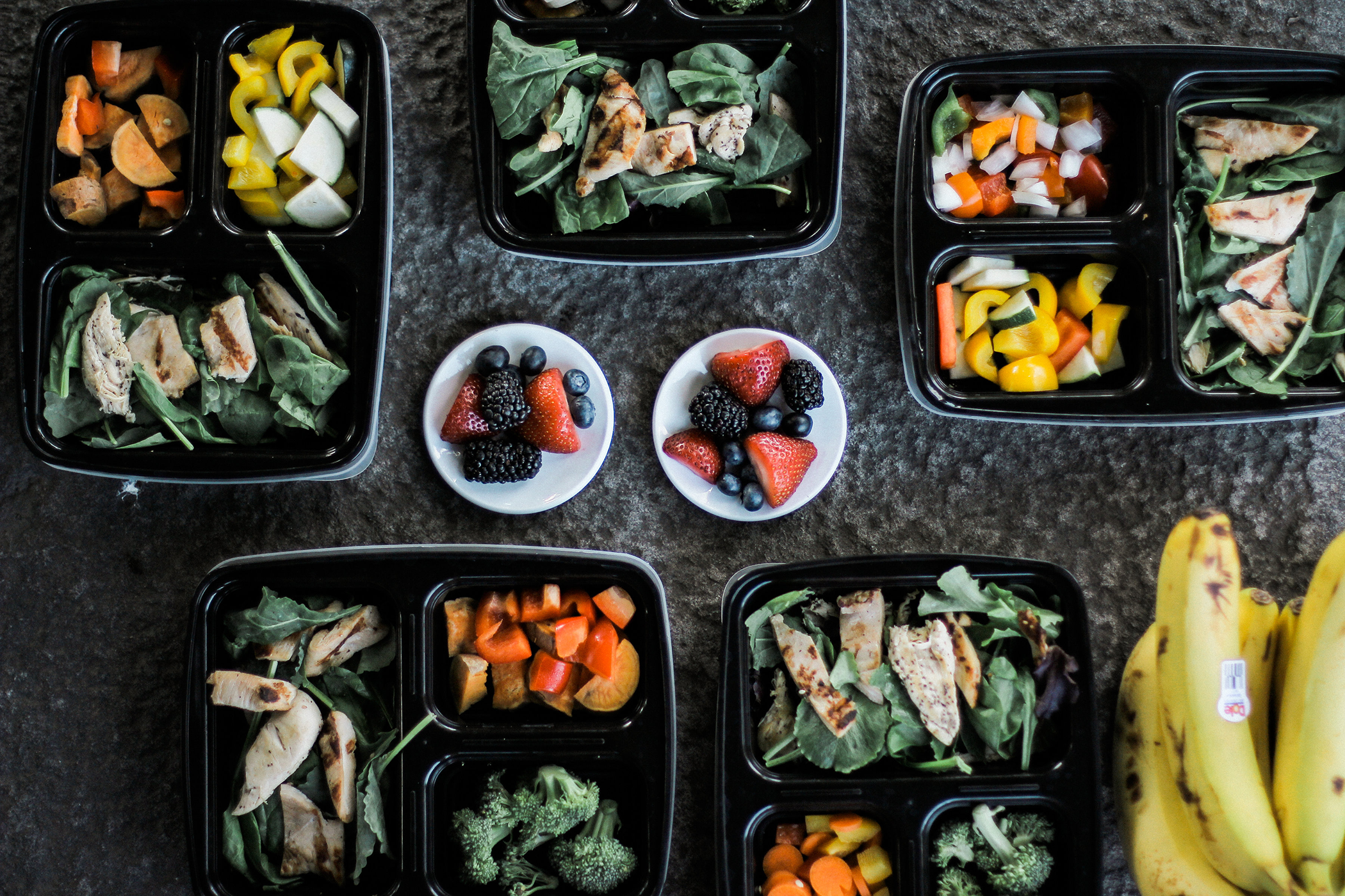 A variety of nutrition-rich food in black trays on a table.