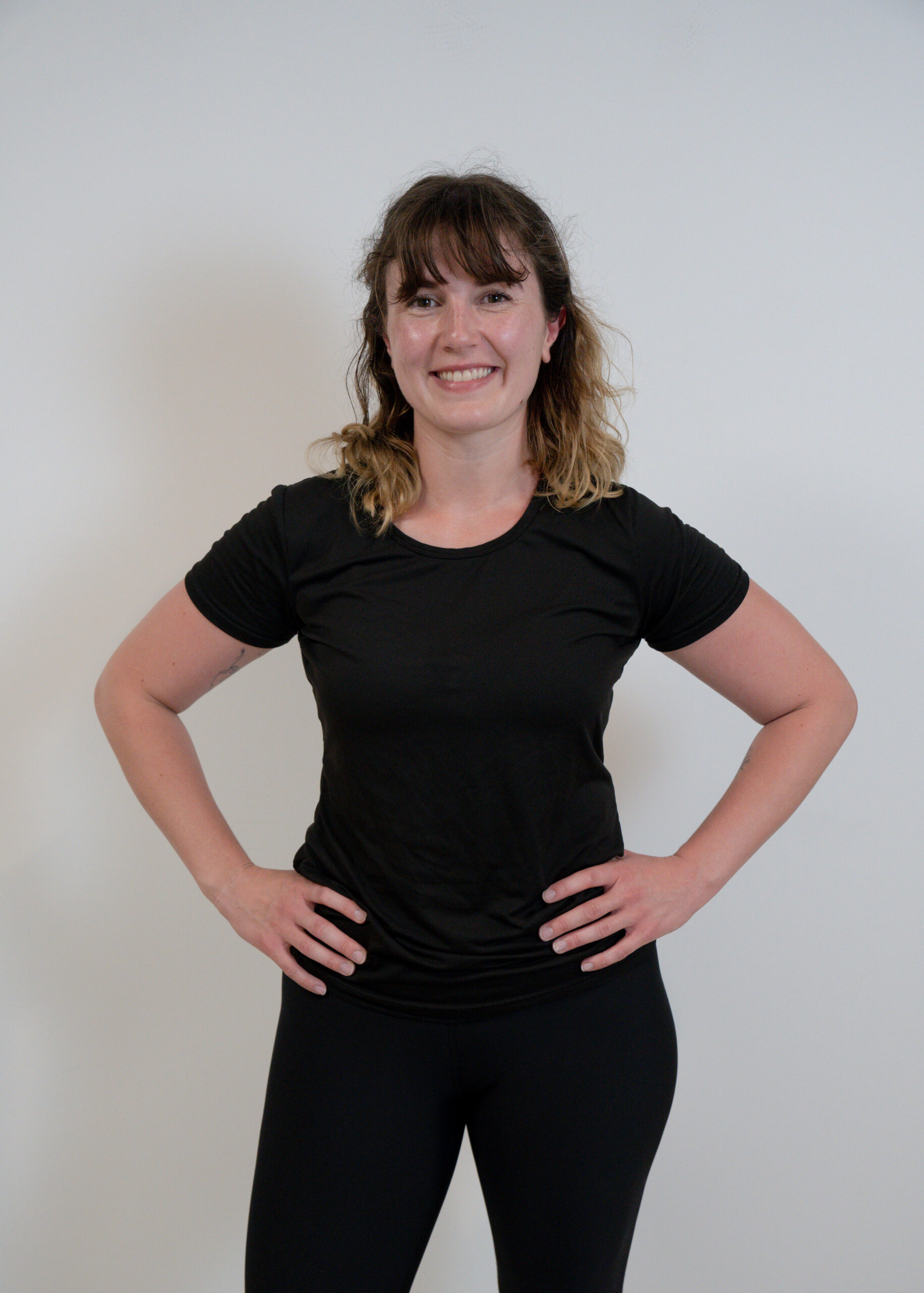 A woman wearing black leggings and a black t-shirt representing a team with strong SEO keywords.