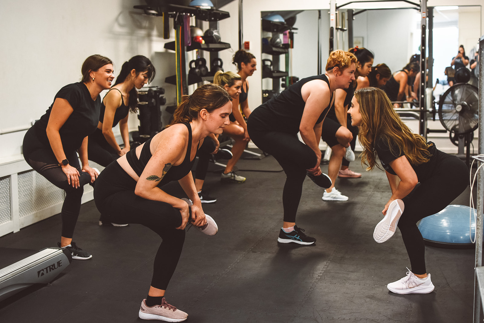 A group of women working out in a home gym.
